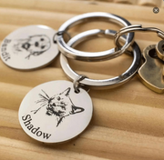 Custom Pet Face Keychain showing engraved round metal tag with cat portrait and name Shadow on wood background