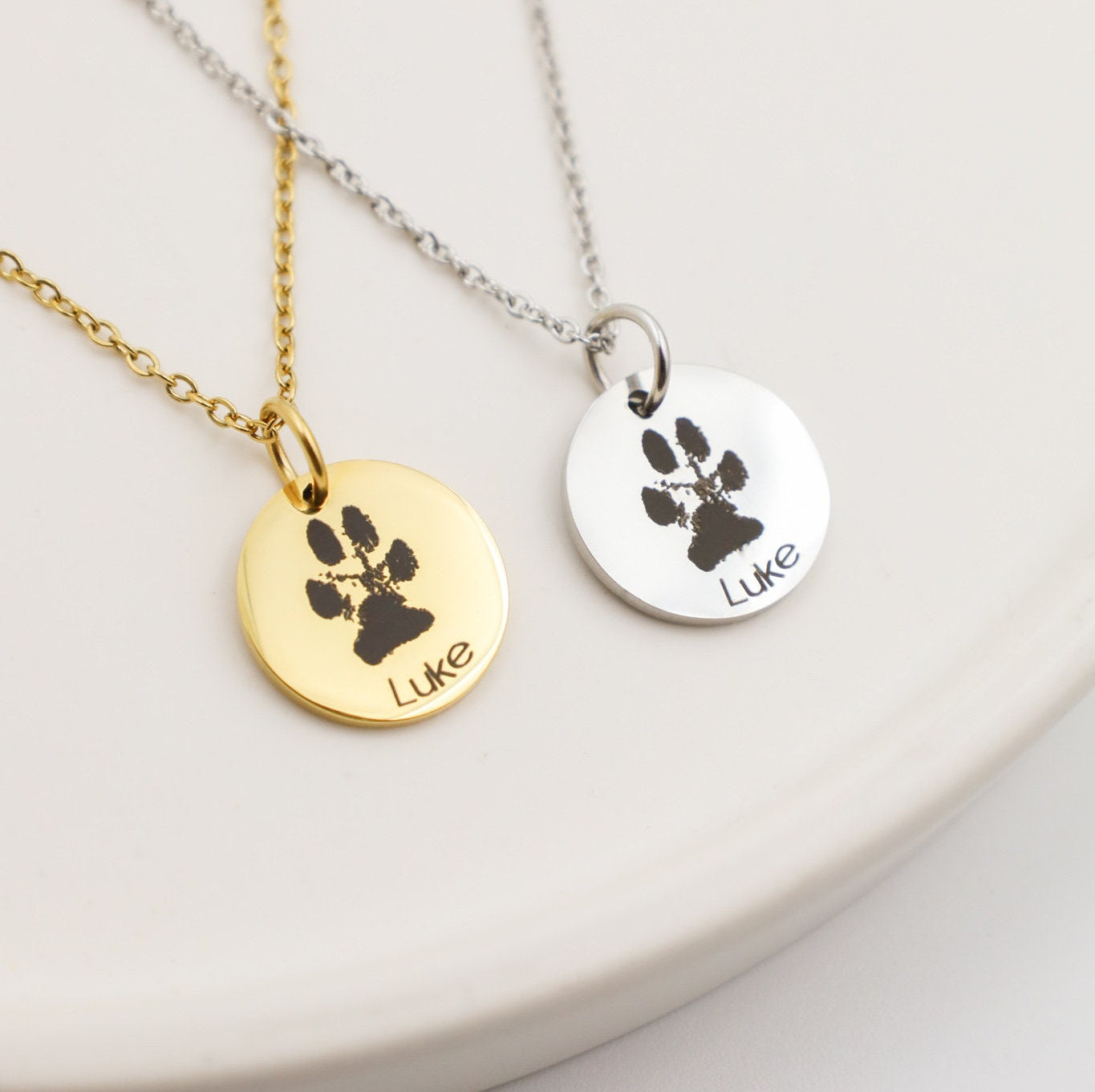 Customized Dog Jewelry featuring paw print pendants in gold and silver for cherished memories